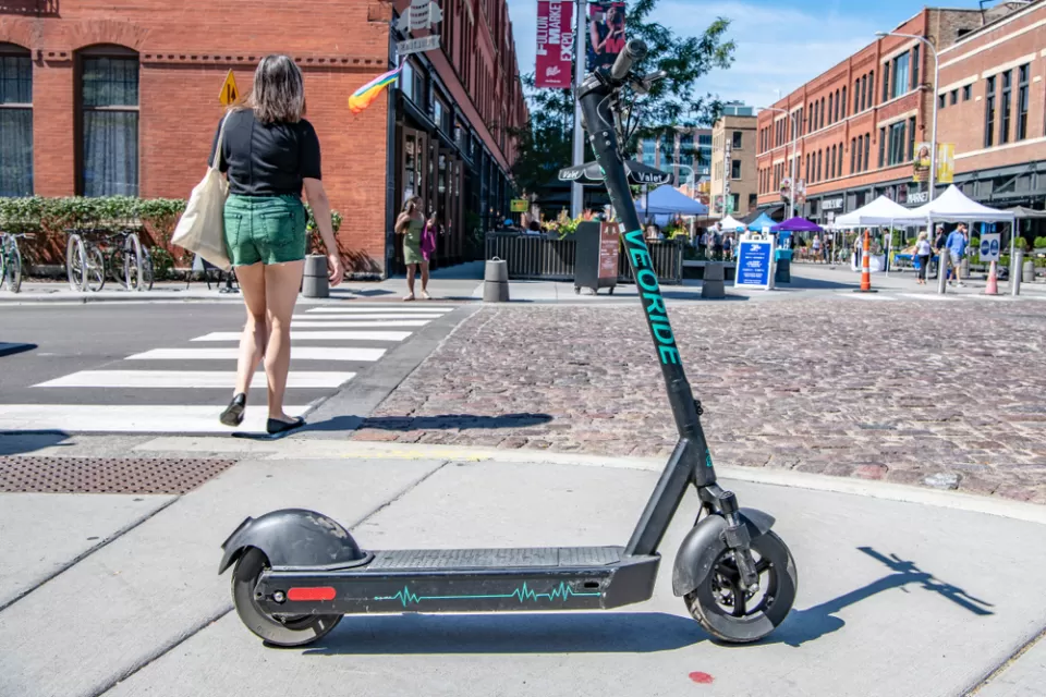 An electric scooter blocks the sidewalk near a street festival in Chicago's West Loop.